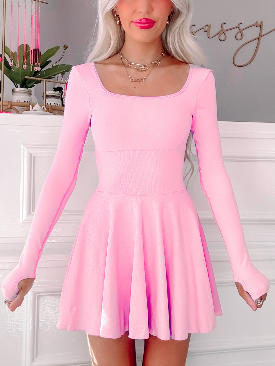 Pink skater dress with long sleeves and thumbholes.
