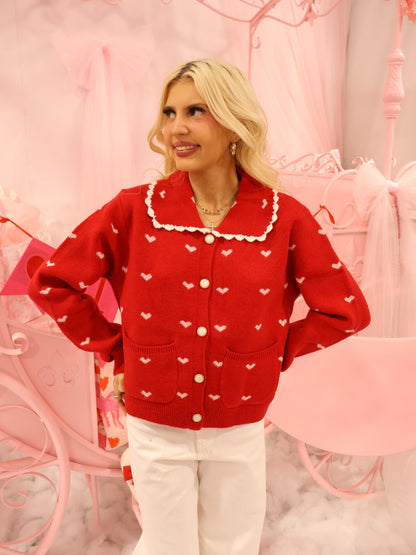 Cupids Collar Red Cardigan Sassy Shortcake – red cardigan with heart details styled with white pants standing pose