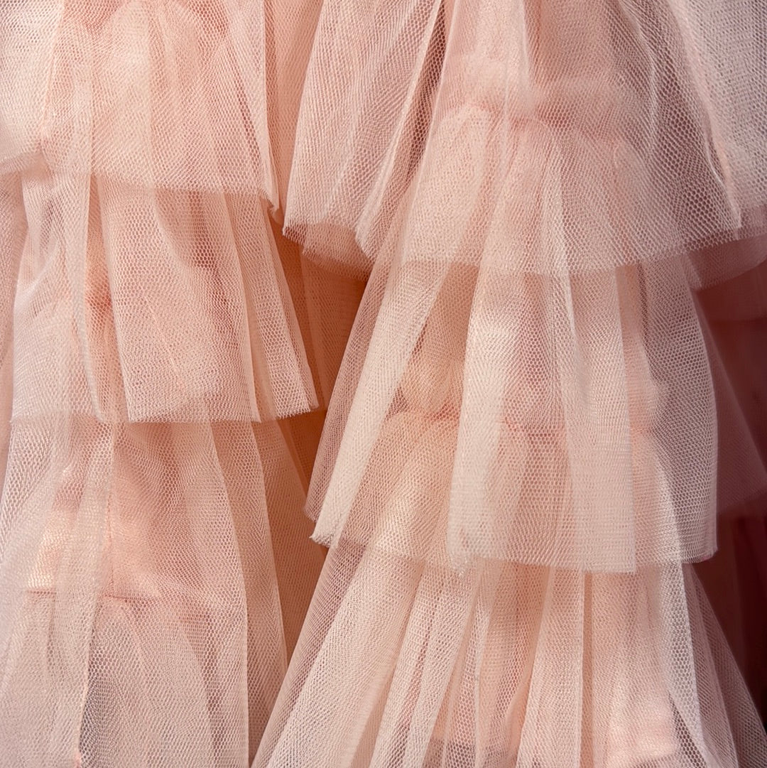Layered blush pink tulle fabric detail, showcasing delicate texture.
