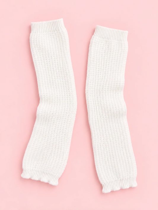 Pair of white Fireside Waffle Knit Leg Warmers with ribbed cuffs laid flat on a pink background from sassy shortcake