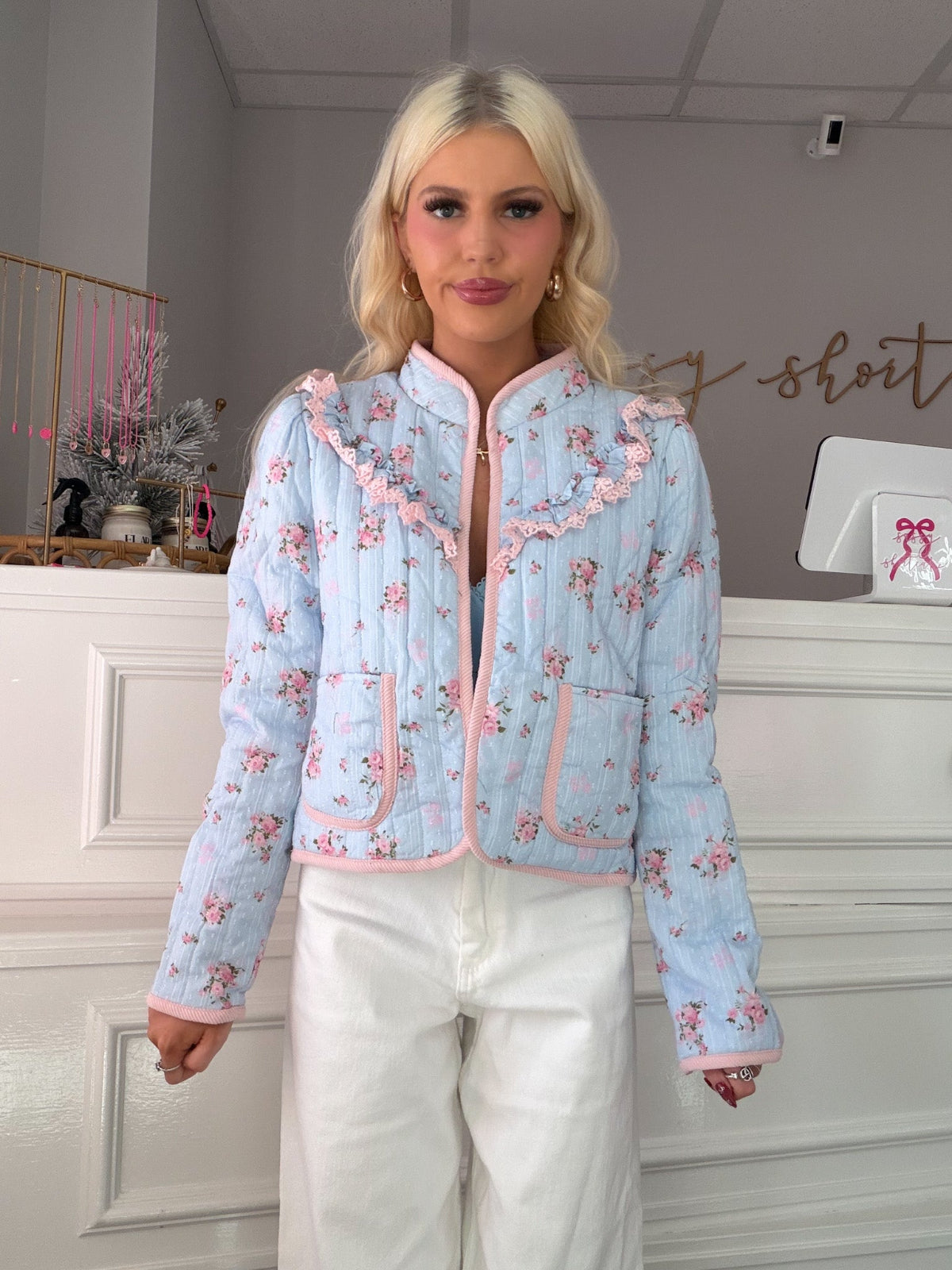 Model wearing Sassy Shortcake Heirloom Bloom floral jacket styled with white pants