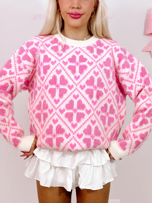Fuzzy pink heart-patterned sweater;  closeup view.
