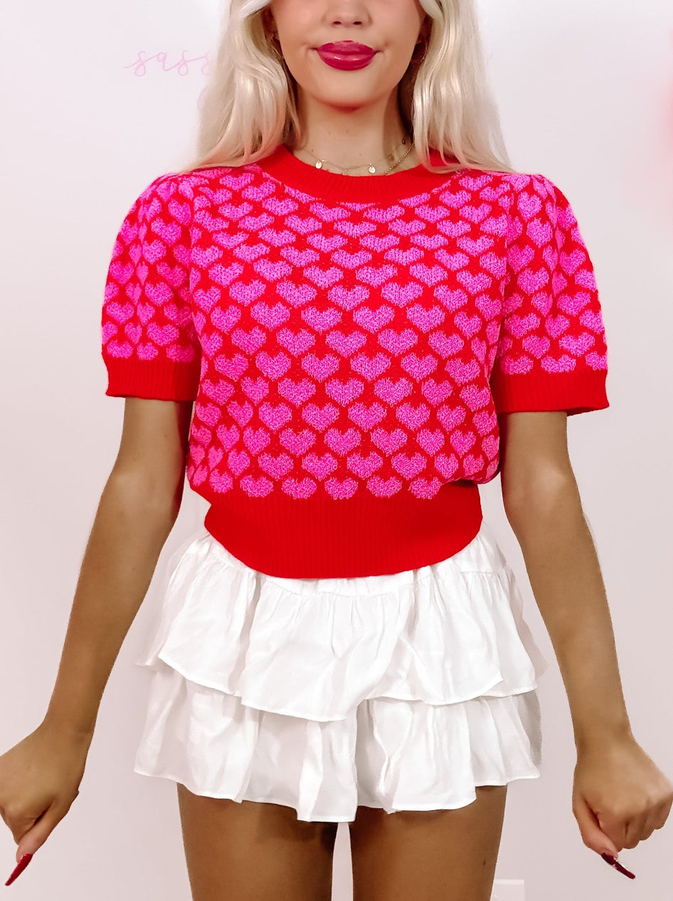 Red heart-print cropped sweater; Valentine's Day top.

