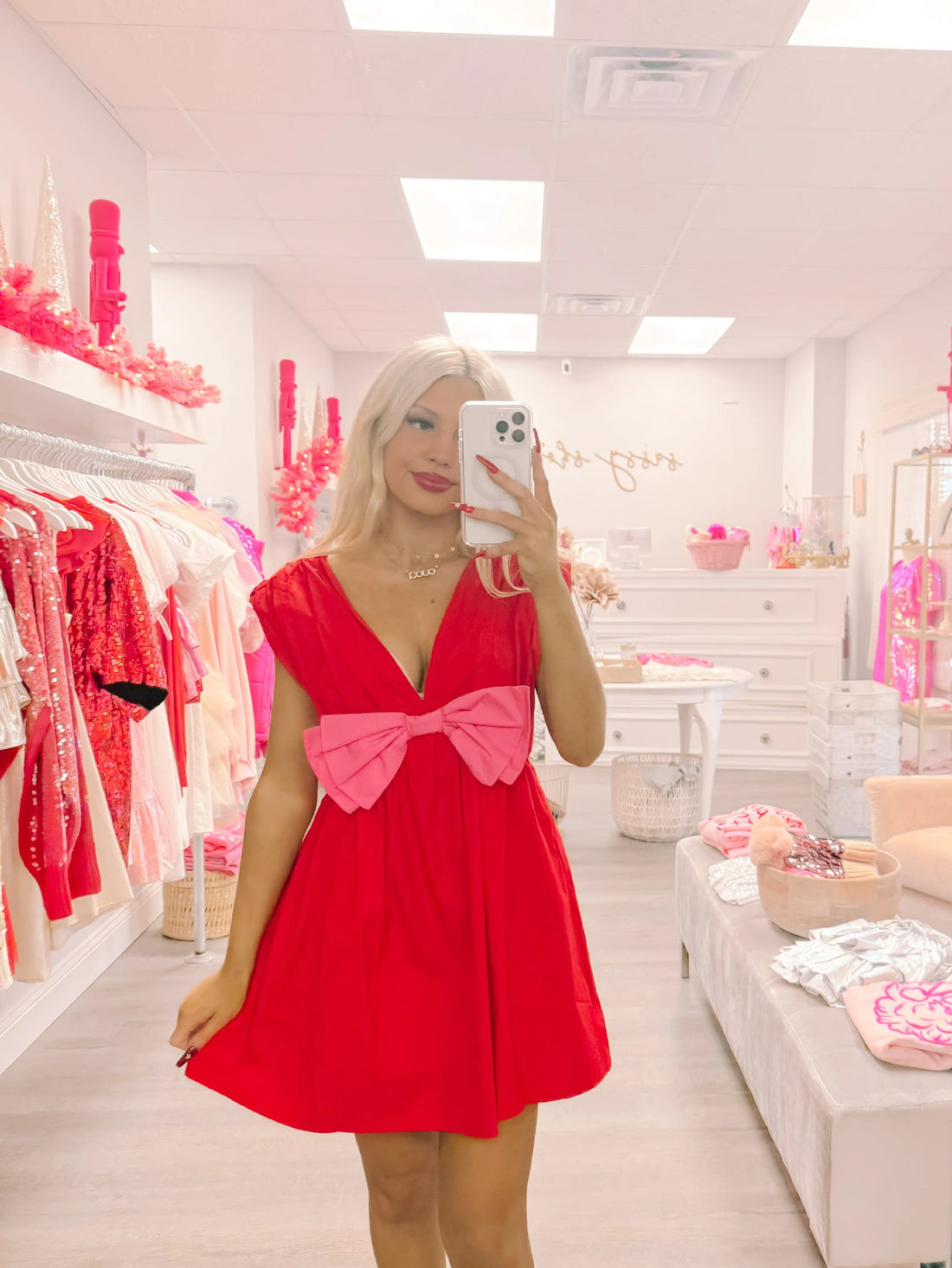 Red mini dress with a pink bow, modeled in Sassy Shortcake boutique. Bow Me Away Valentine's Day Dress
