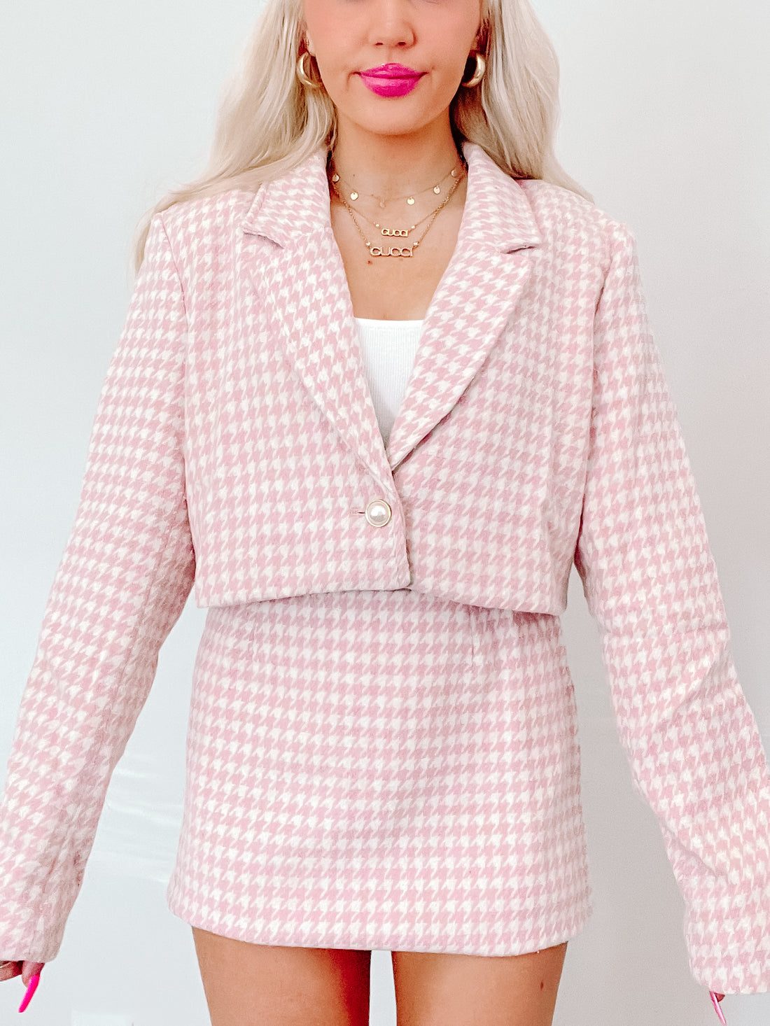 Pink houndstooth cropped blazer and mini skirt set; stylish and chic.
