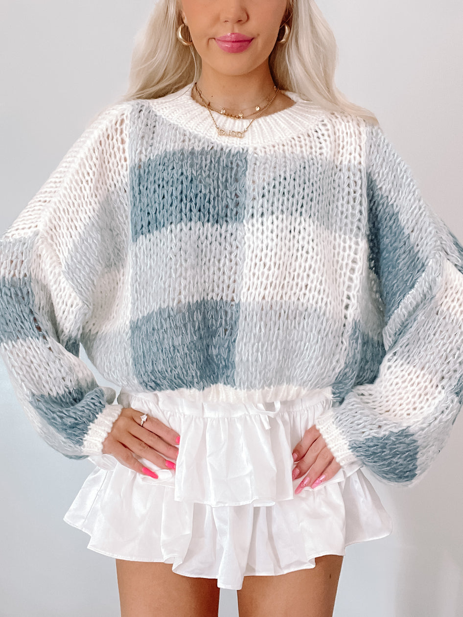 Chunky knit sweater in blue and white color-blocked pattern, shown on model.
