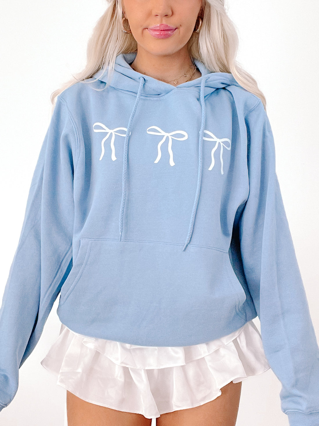 Blushing Bow Hoodie in light blue featuring three white bows.
