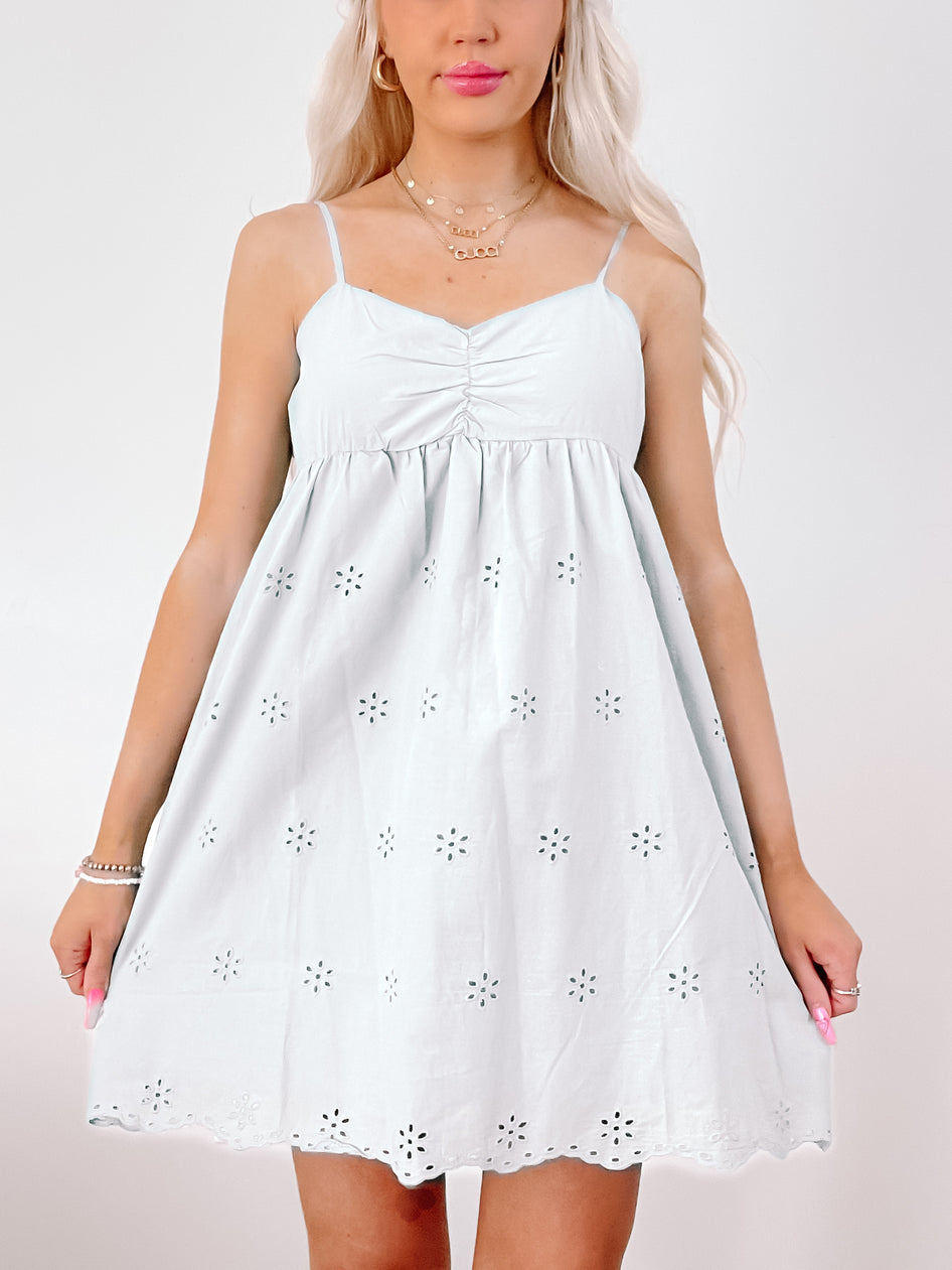 Eyelet-detail mini dress in light blue; features a fitted bodice and flowy skirt.
