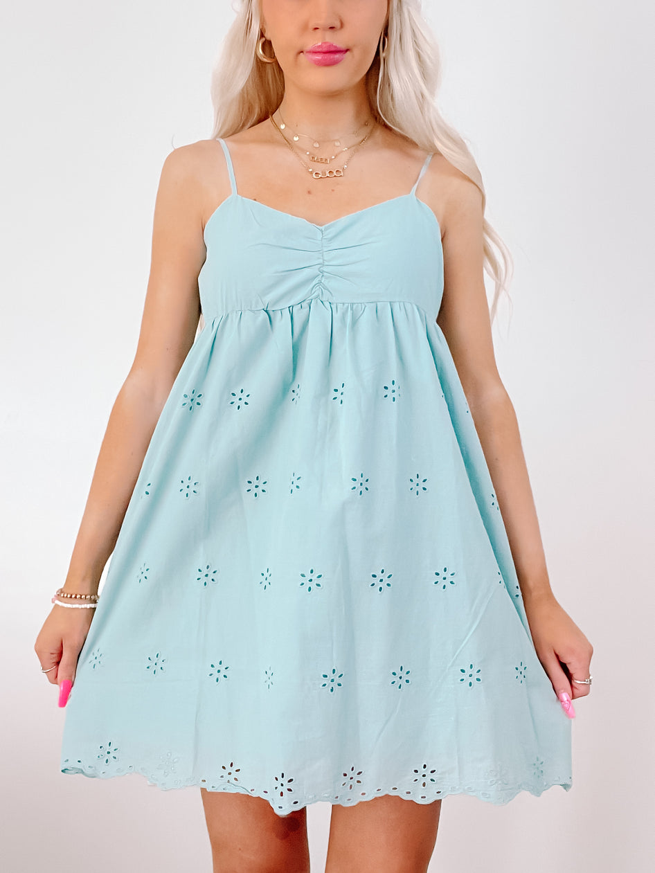 Eyelet-embellished teal blue sundress, summer fashion.
