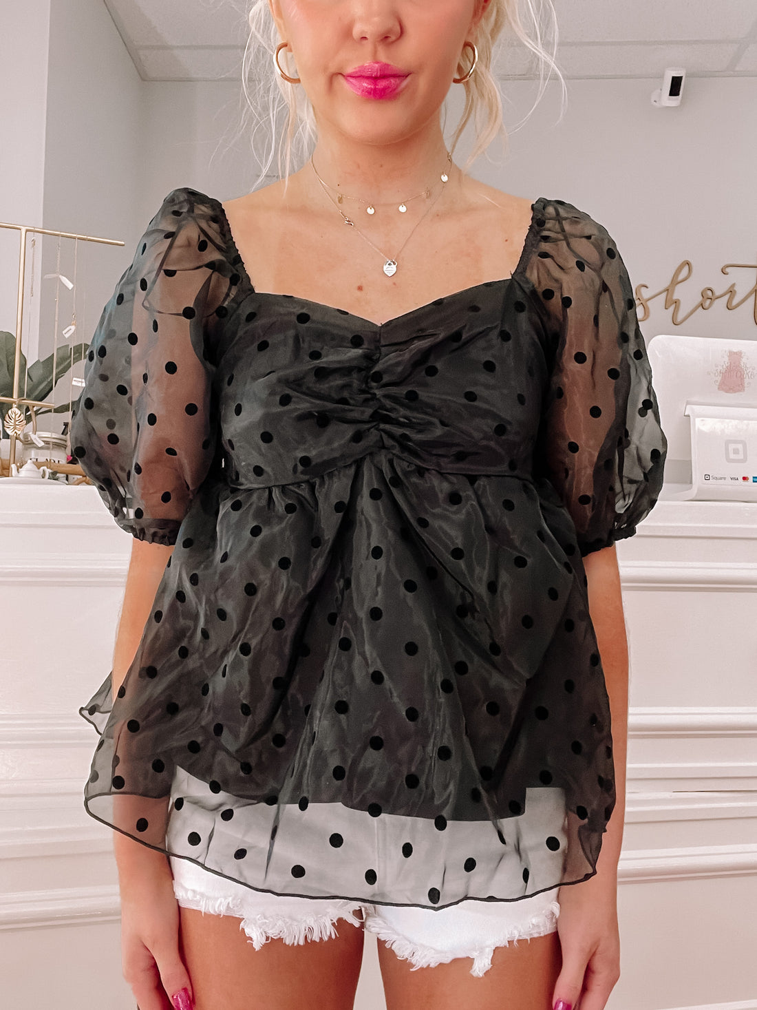 Black polka dot sheer top with puff sleeves and a sweetheart neckline.
