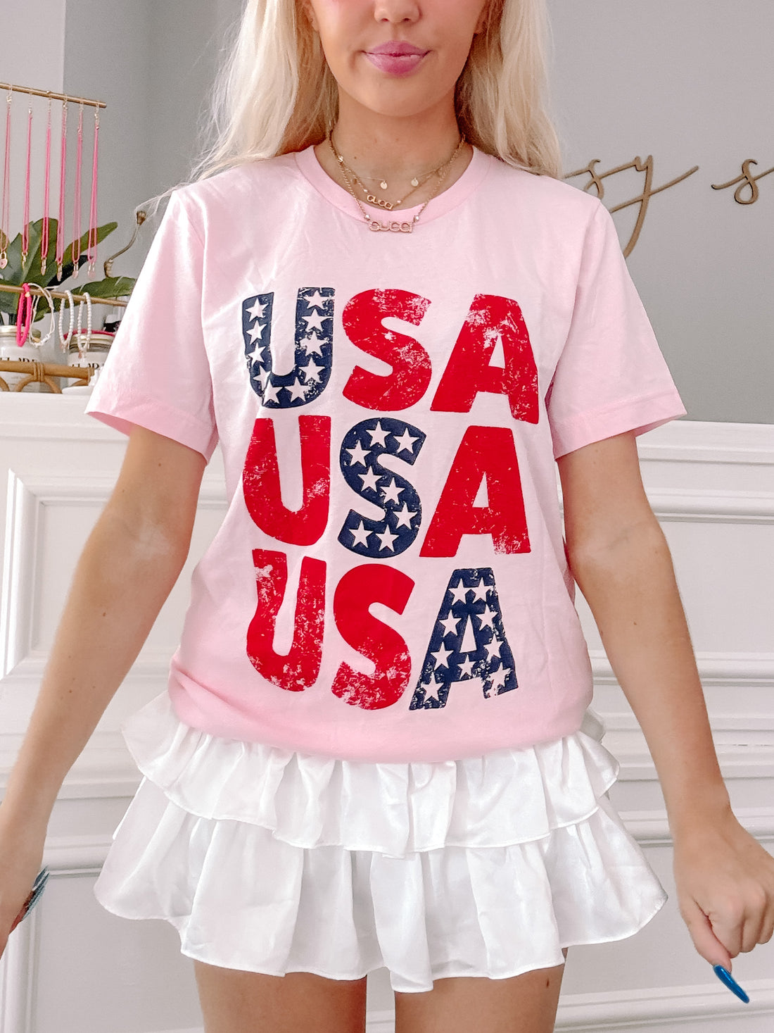 Baby pink USA tee with red, white, and blue distressed graphic.
