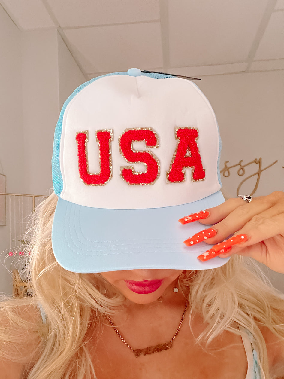 USA Hat: Light blue trucker hat with red, white, and gold "USA" lettering.
