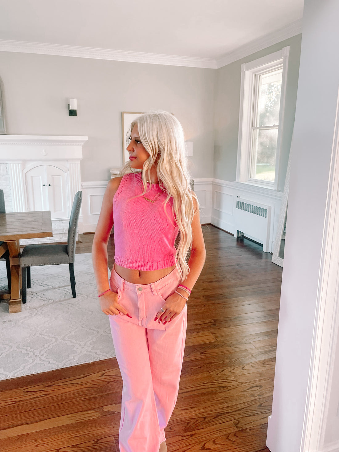 Pink knit vest top styled in a bright, airy room.
