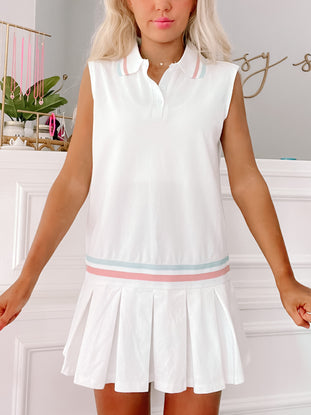 White pleated tennis dress with pastel pink and blue trim; "In It To Win It" dress.
