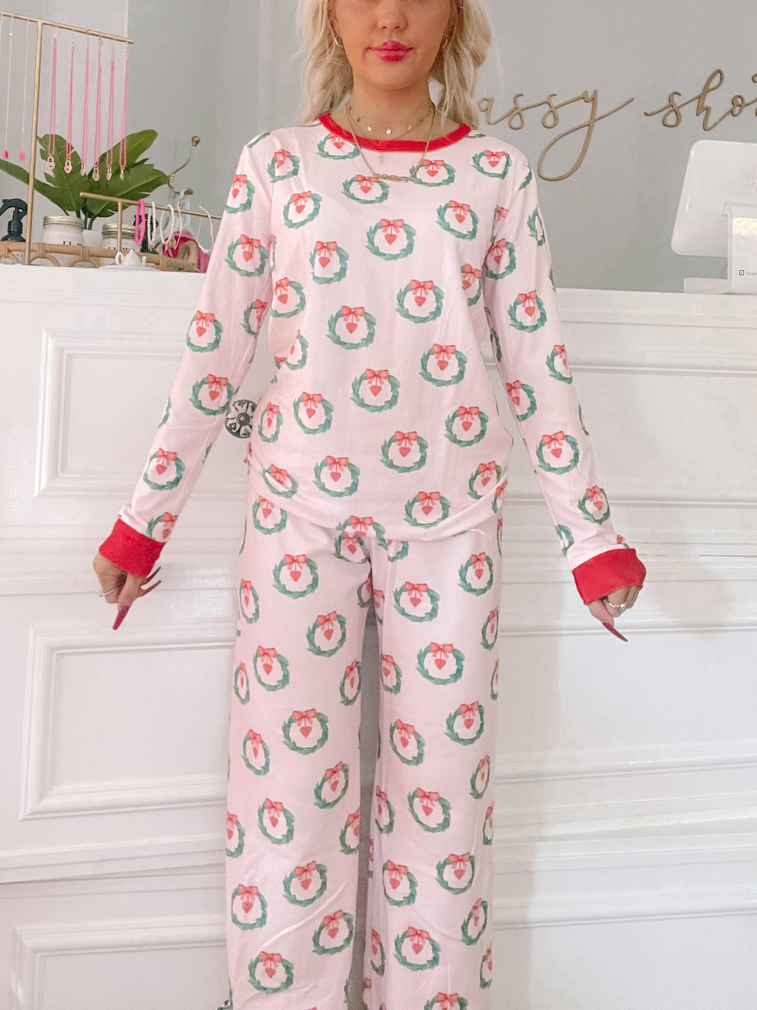 Pink pajama set with a festive wreath print; long sleeves and pants.
