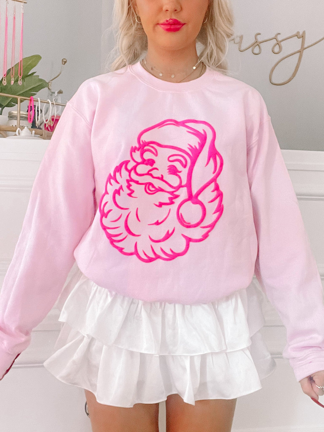 Pink sweatshirt featuring a neon pink Santa Claus graphic; styled with a white ruffled skirt from Sassy Shortcake
