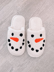 Cozy snowman slippers, white fuzzy fabric with embroidered face.
