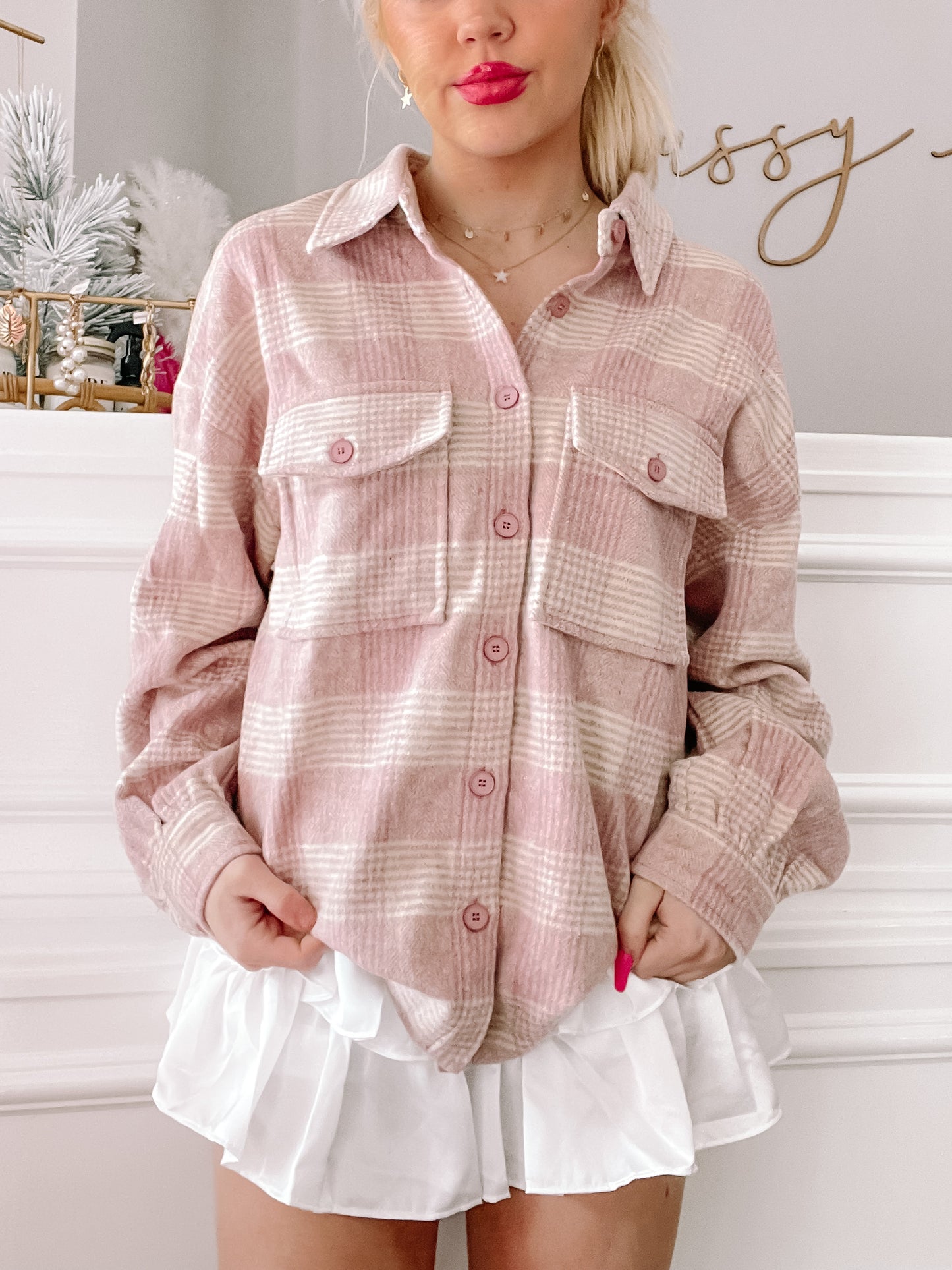 Pink and white plaid shacket styled with a white ruffled skirt.
