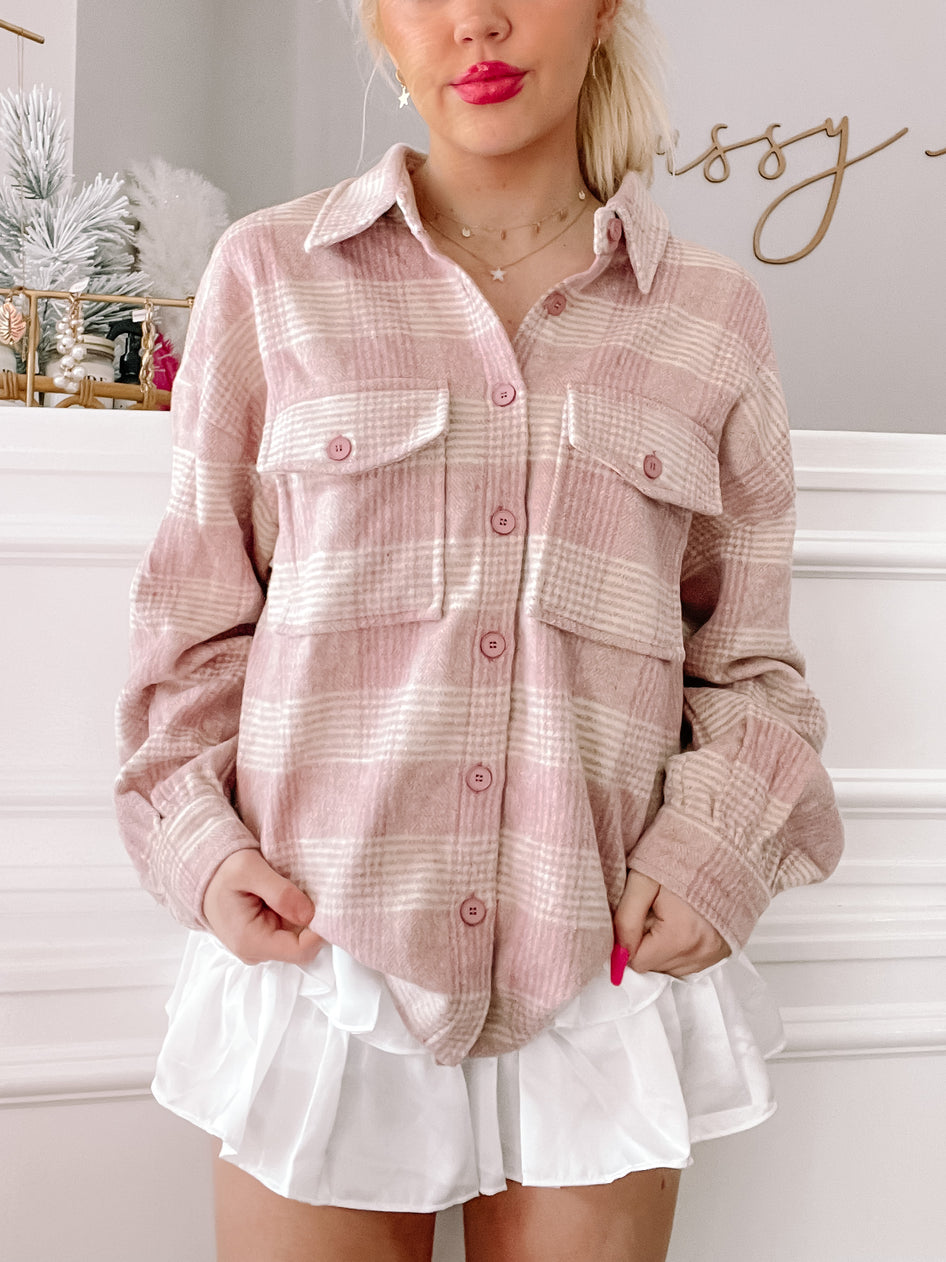 Pink and white plaid shacket styled with a white ruffled skirt.
