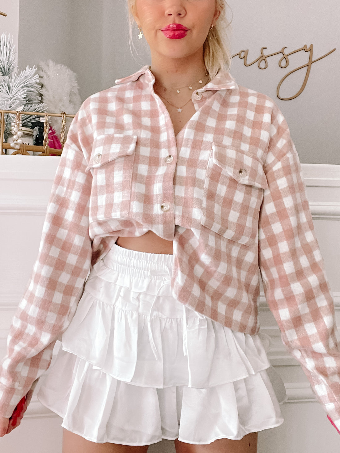 Pink and white gingham button-up shacket styled with a white ruffle skirt.
