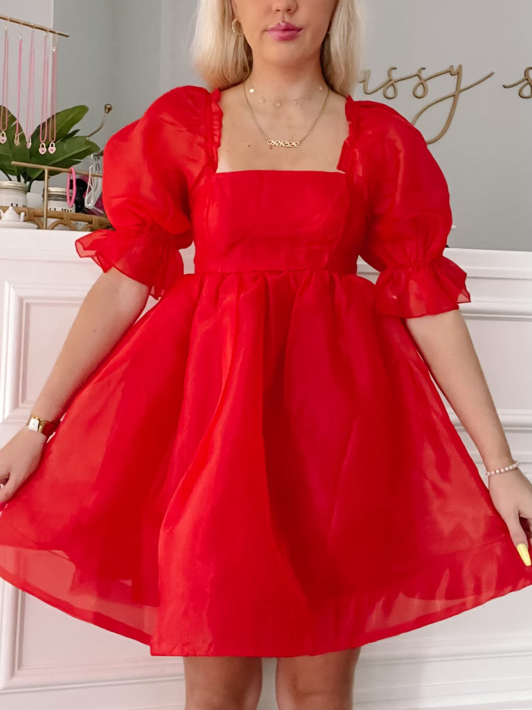 Blush-colored mini dress with puff sleeves; square neckline and a-line silhouette.
