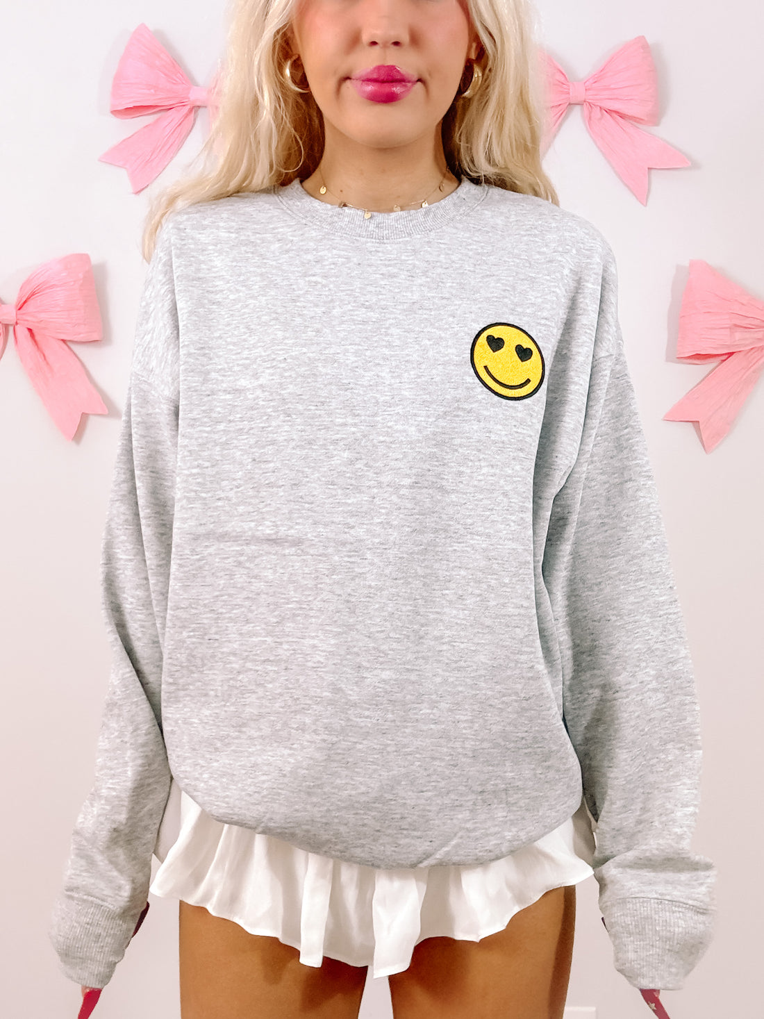 Grey Happy Heart crewneck sweatshirt with heart-eyed smiley face detail
