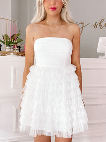 White ruffle mini dress with tiered skirt, perfect for parties or special occasions.

