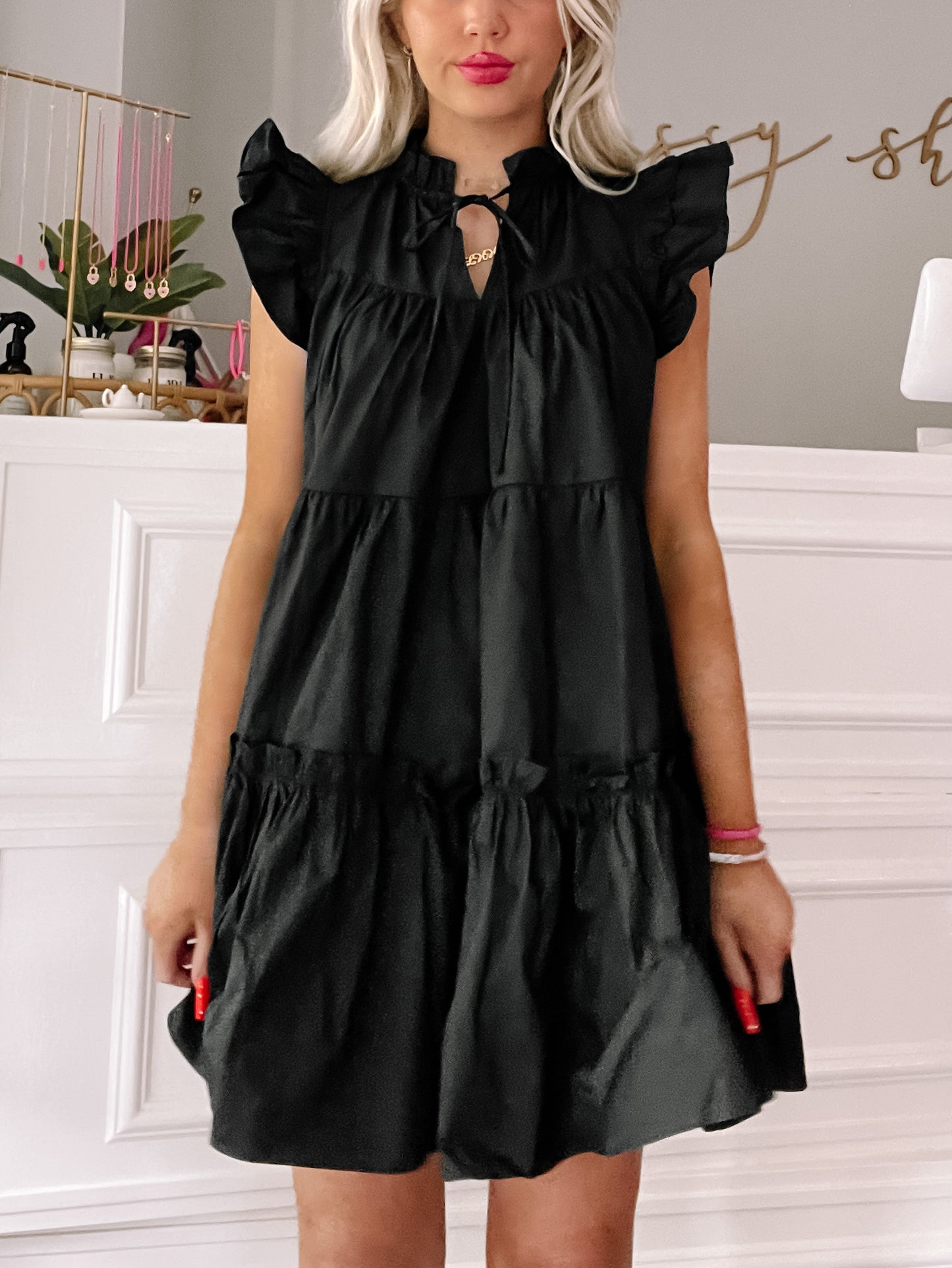 Black tiered ruffle mini dress with a tie neck
