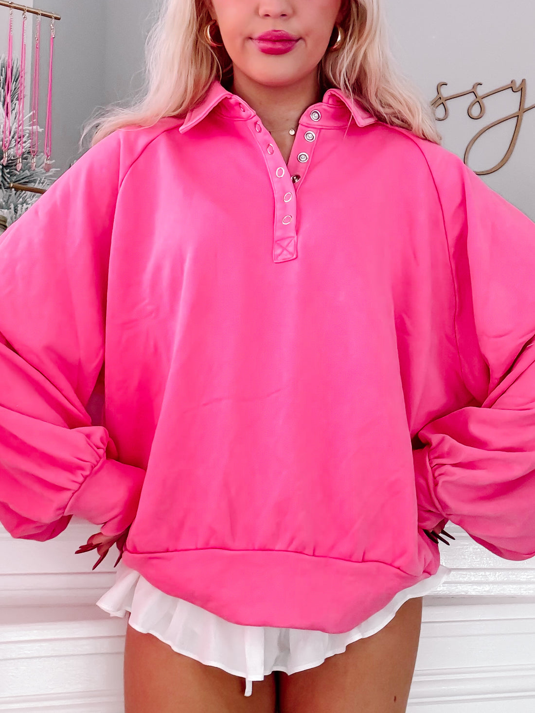 Hot pink pullover with a collared neckline and balloon sleeves, modeled against a white backdrop.

