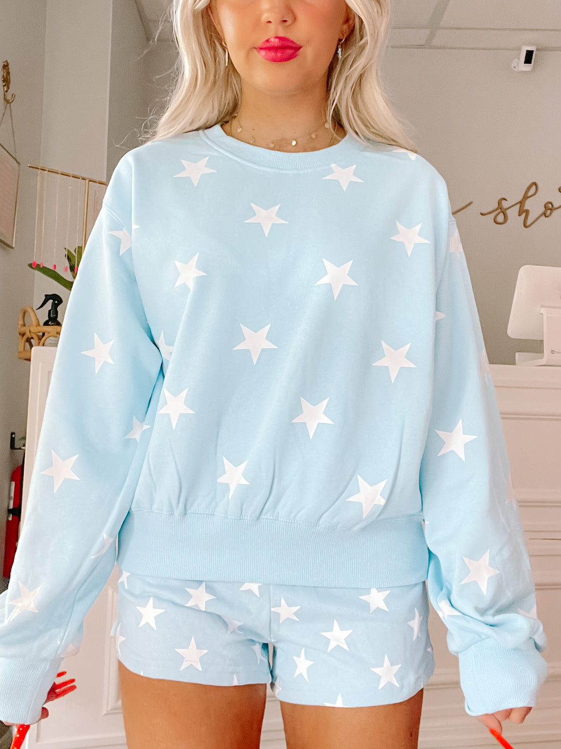 Light blue star print sweatshirt and shorts set; casual, comfortable loungewear.
