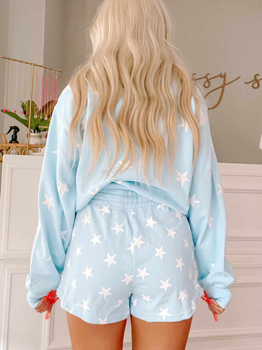 Light blue shorts with white stars, worn with a matching sweatshirt.
