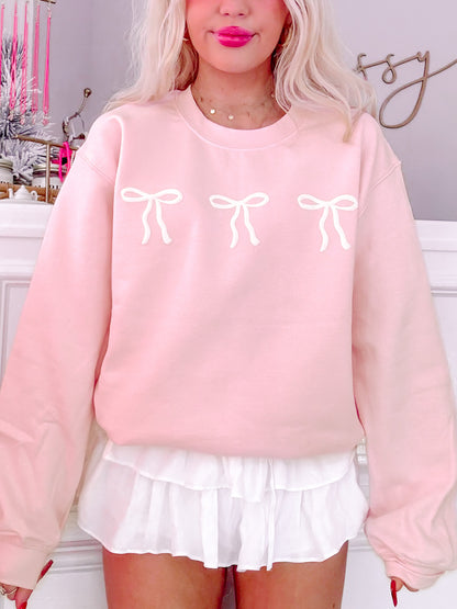 Rose pink Blushing Bow Crewneck sweatshirt with three white bows.
