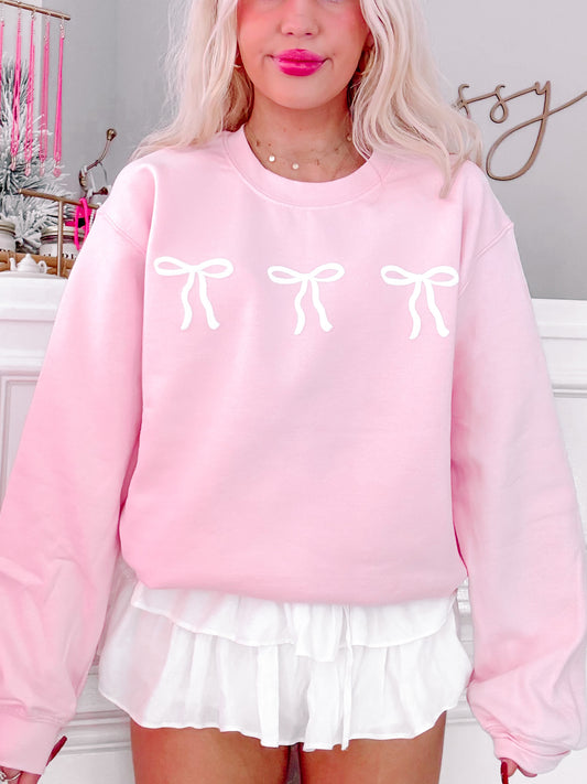 Pink Blushing Bow Crewneck sweatshirt with three white bows.
