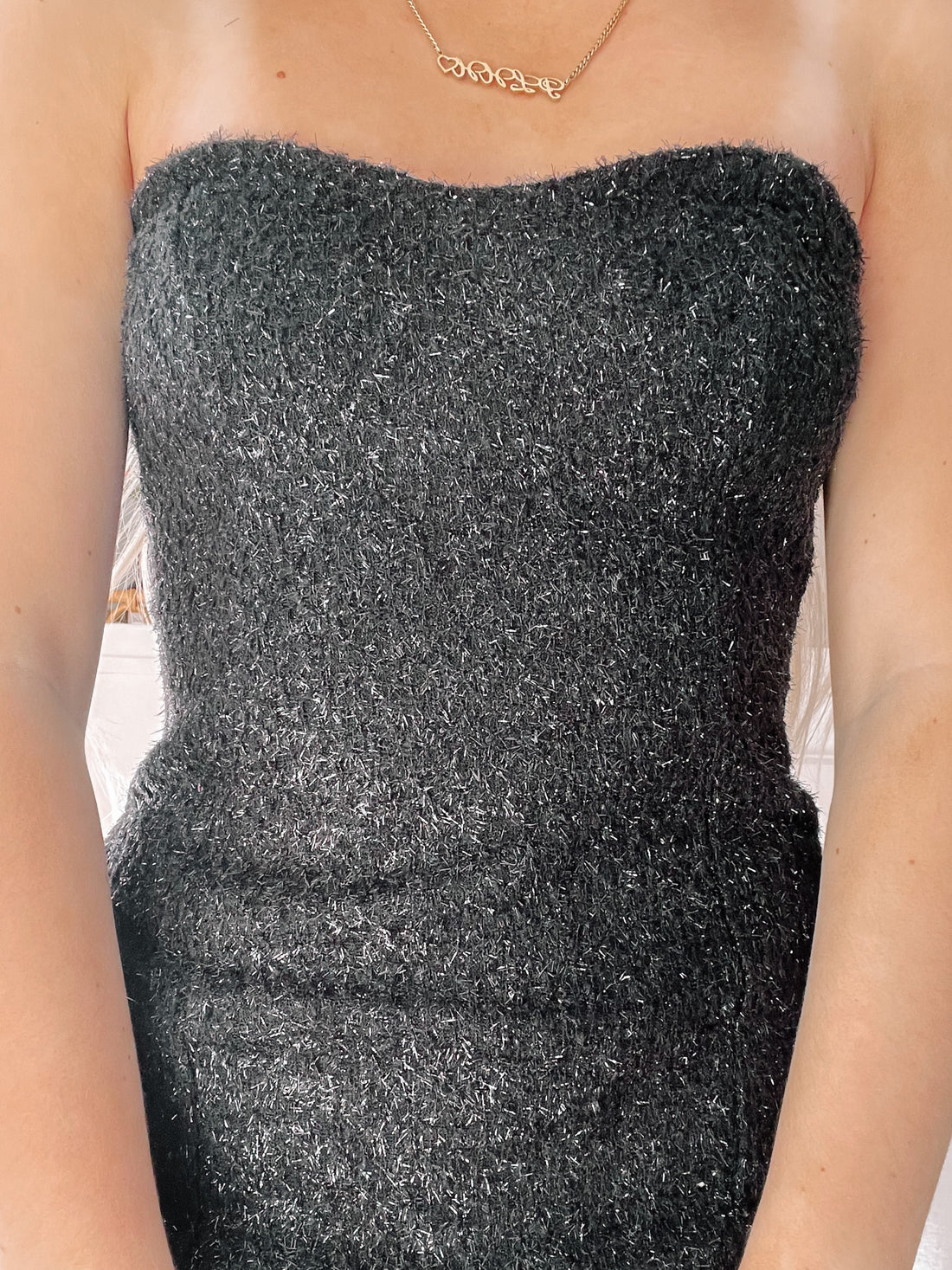 Sparkly black strapless mini dress, detailed close-up.
