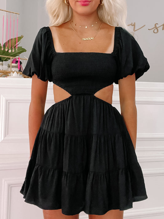 Black mini dress with puff sleeves and cut-out detail, tiered skirt.