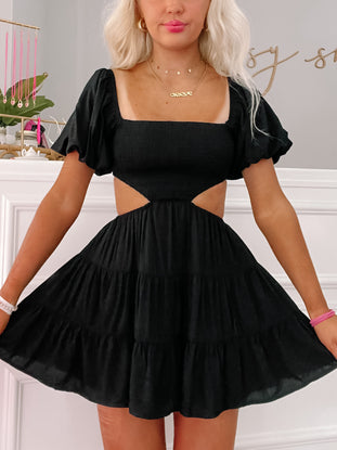 Black Clementine Cutie mini dress with cut-out sides and puff sleeves.
