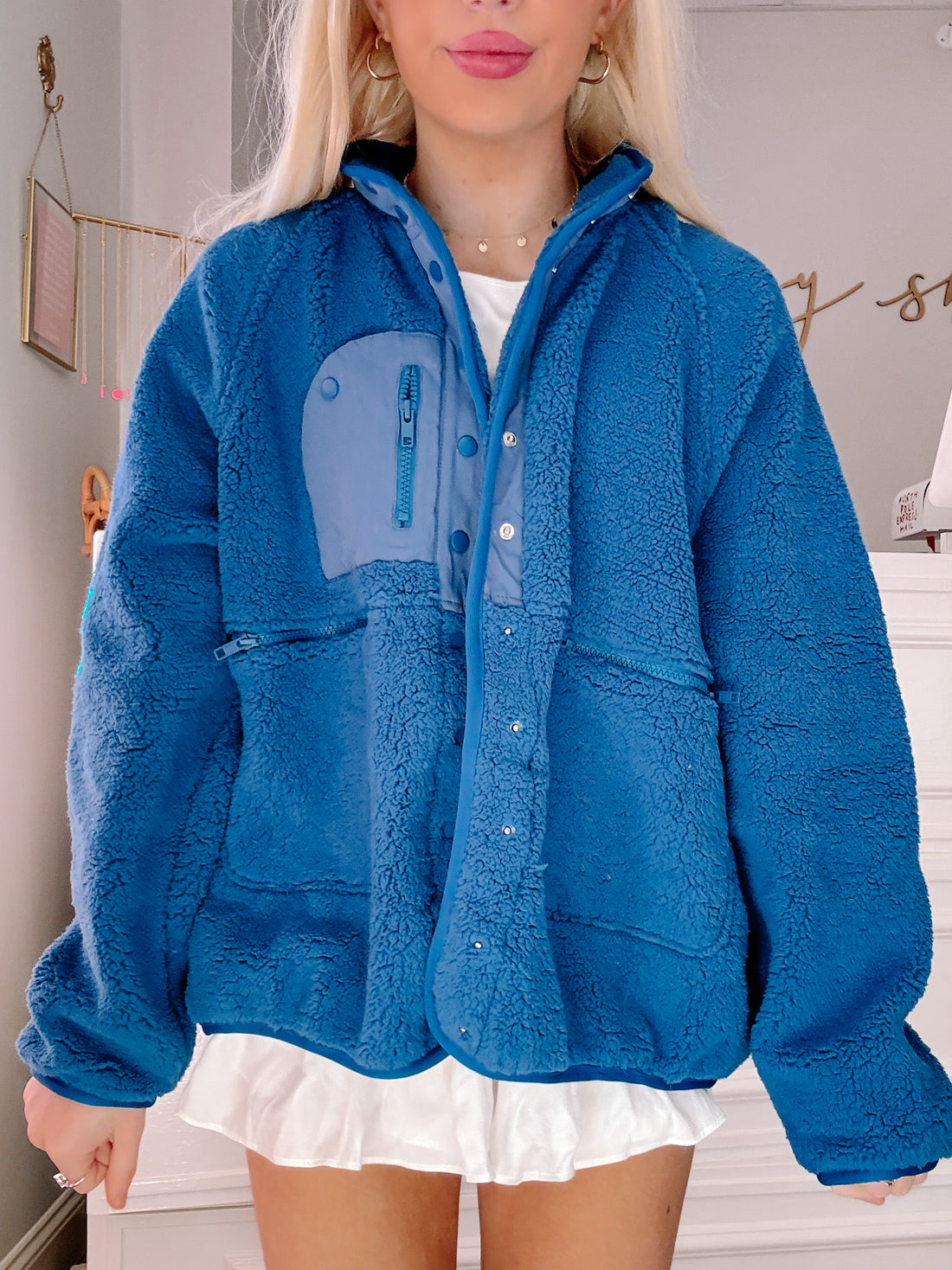 Blue sherpa jacket with contrasting pocket detail, shown on a model.
