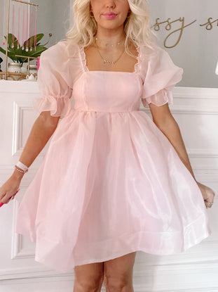 Blush pink mini dress with puff sleeves, square neckline; shown on model.
