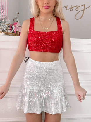 Silver sequin mini skirt with fringe detail, shown on a model.
