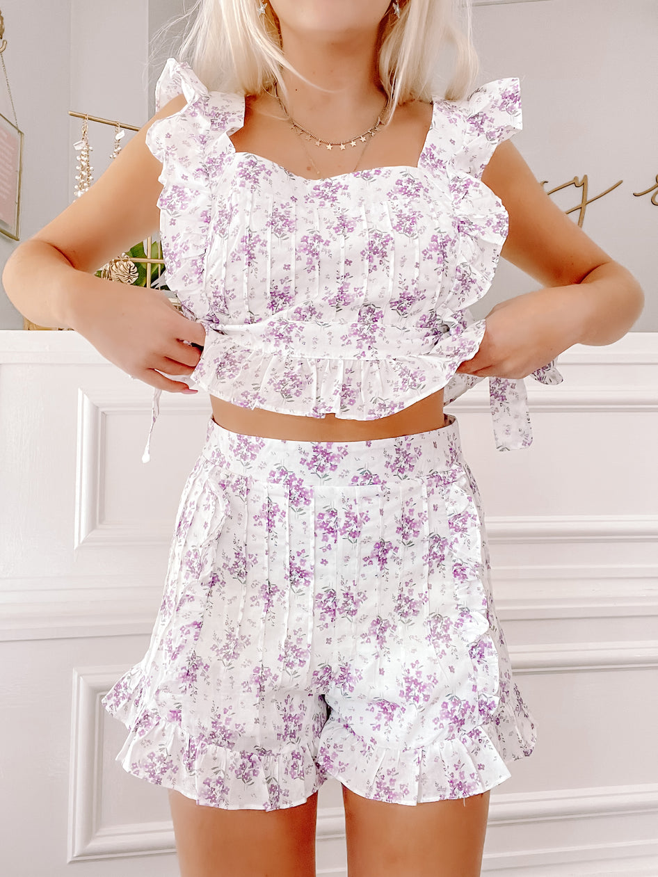 Linen lilac floral print two-piece set; ruffle trim on the cropped top and shorts.
