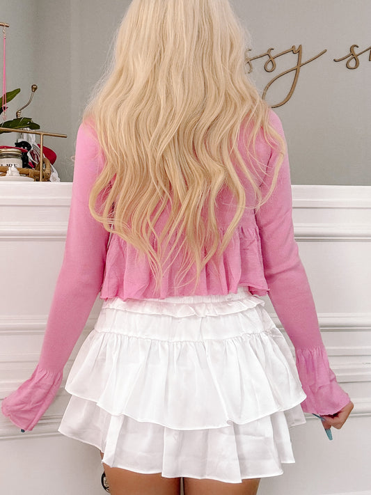 Pink cropped sweater and tiered white ruffle skirt combo, shown from the back.