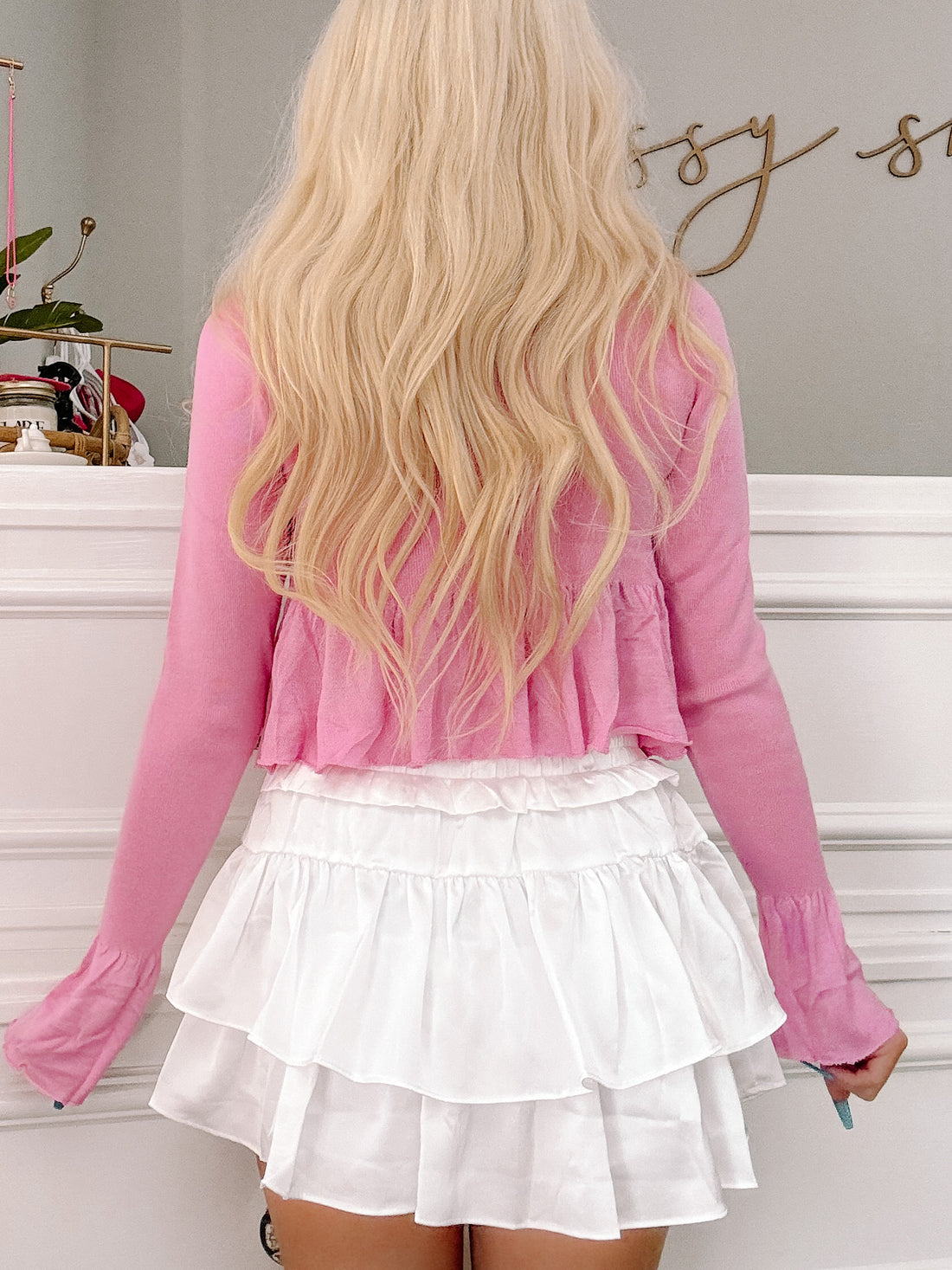 Pink cropped sweater and tiered white ruffle skirt combo, shown from the back.
