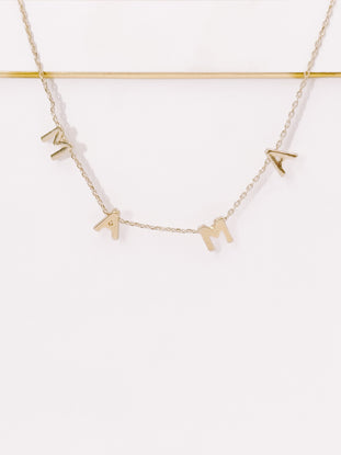 Gold "Mama" necklace on white background, delicate chain.

