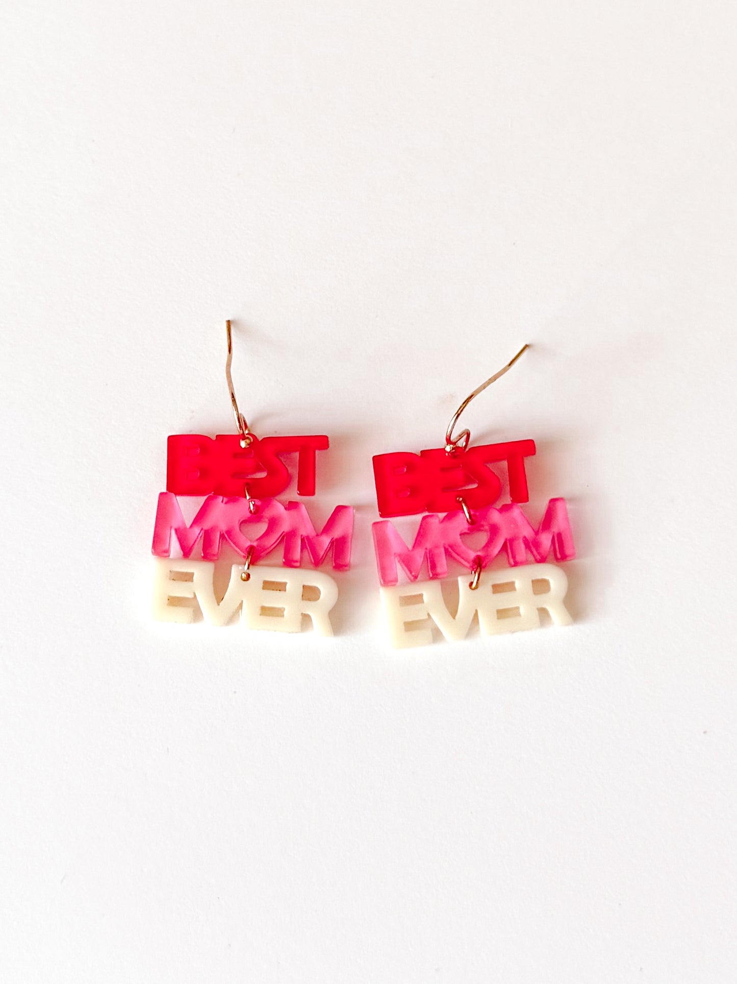 Pink and white acrylic "Best Mom Ever" earrings on white background.
