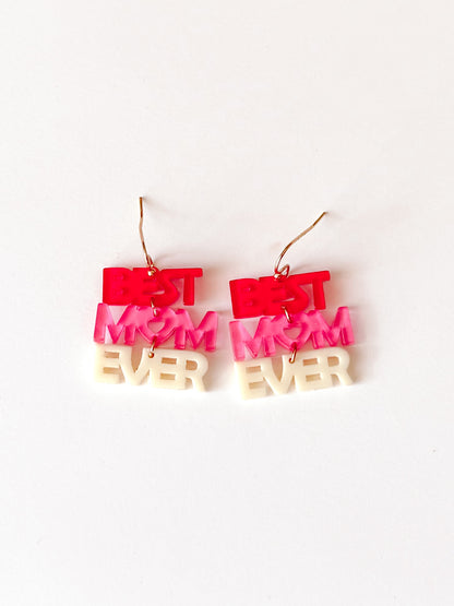 Pink and white acrylic "Best Mom Ever" earrings on white background.
