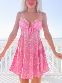 Pink mini dress with white stars, cutout details, and ruffled straps.
