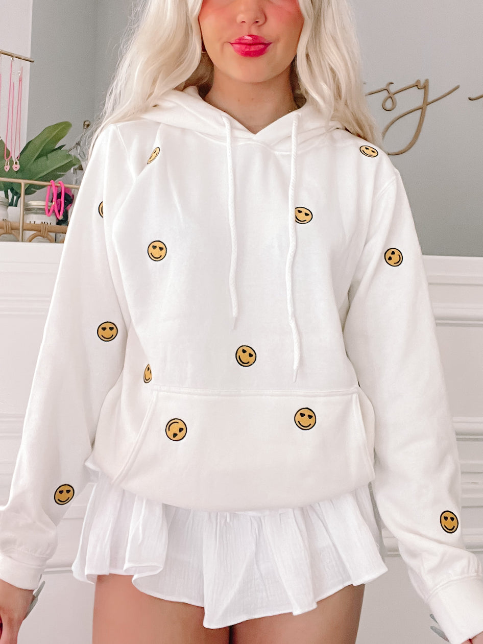 White Happy Hearts Hoodie with embroidered smiley faces.
