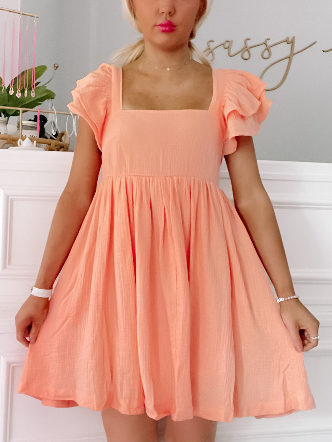Peach Blissfully Orange dress with ruffled short sleeves and square neckline.

