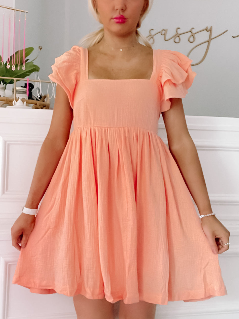 Peach Blissfully Orange dress with ruffled short sleeves and square neckline.
