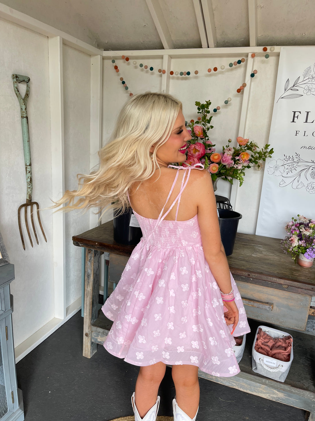 Pink floral dress, worn outdoors in a flower shop setting.
